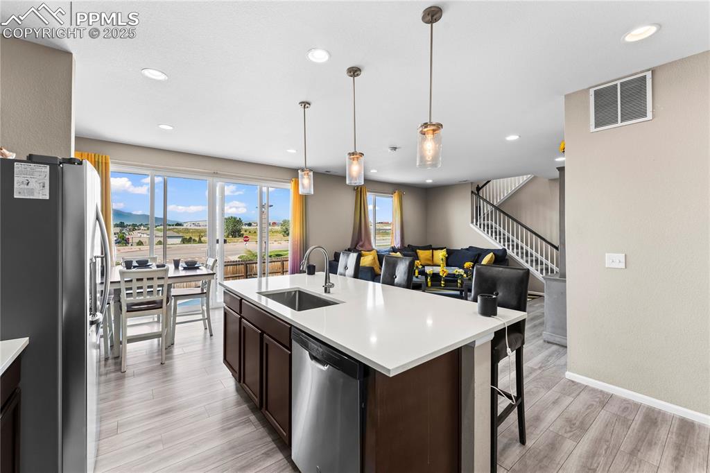 Image 9 of 32: Kitchen featuring appliances with stainless steel finishes, pendant lightin