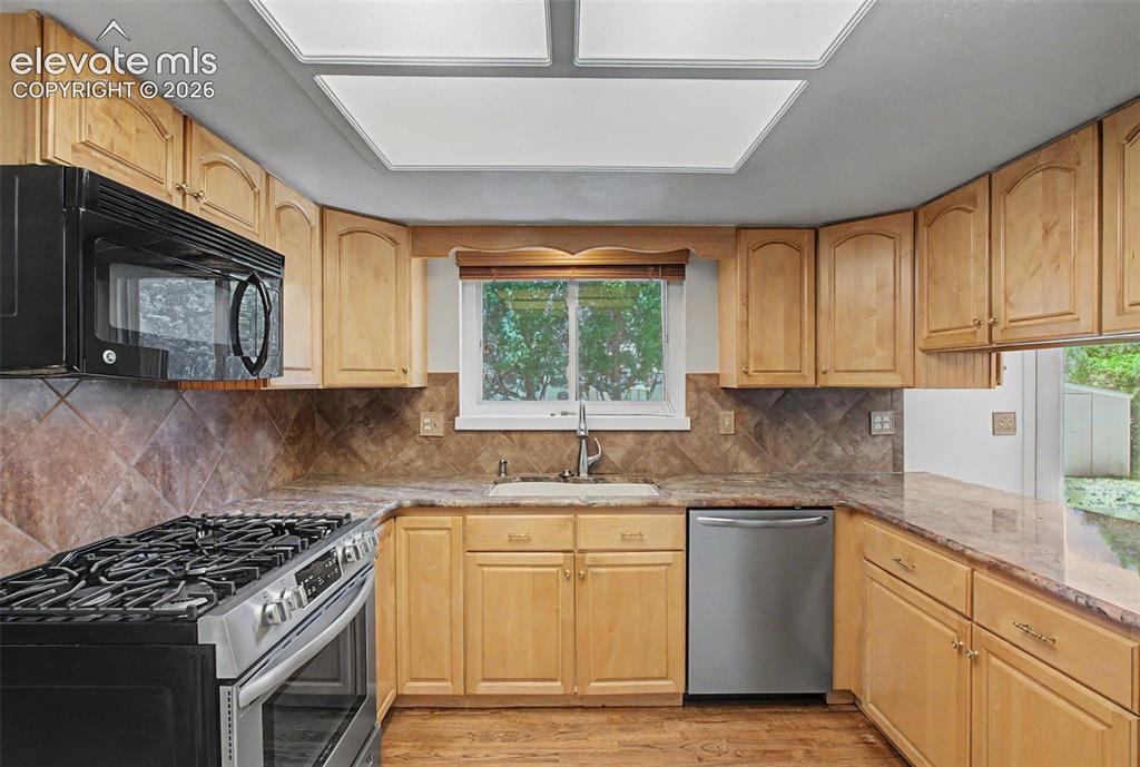 Image 12 of 49: The kitchen presents with gorgeous granite countertops and comes equipped w