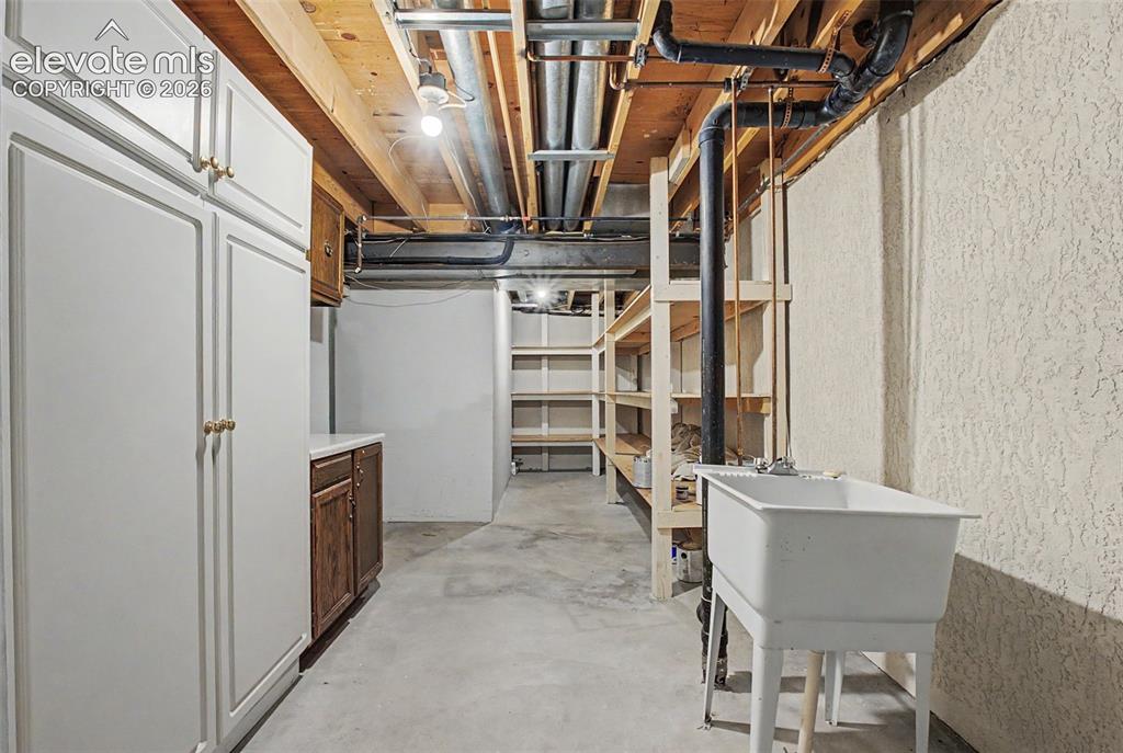 Image 44 of 49: The unfinished portion of the basement offers storage and a utility sink!