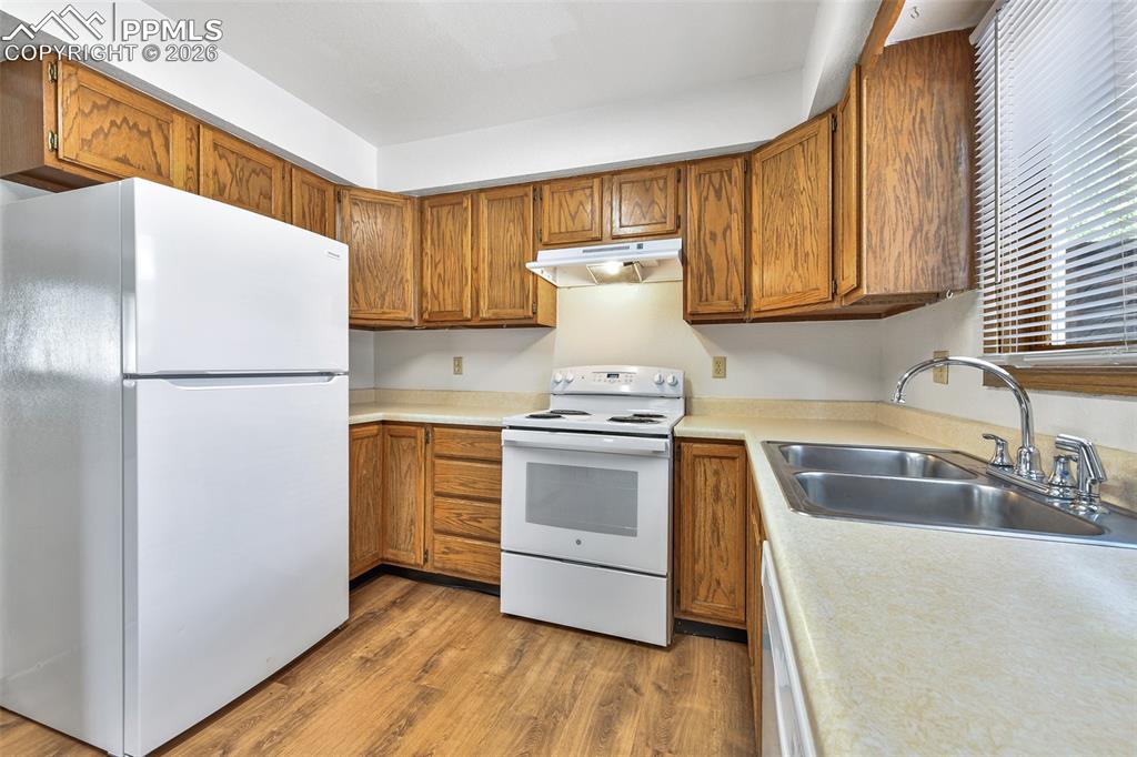 Image 8 of 22: Kitchen With Double Stainless Steel Sinks, Range/Oven, And Refrigerator