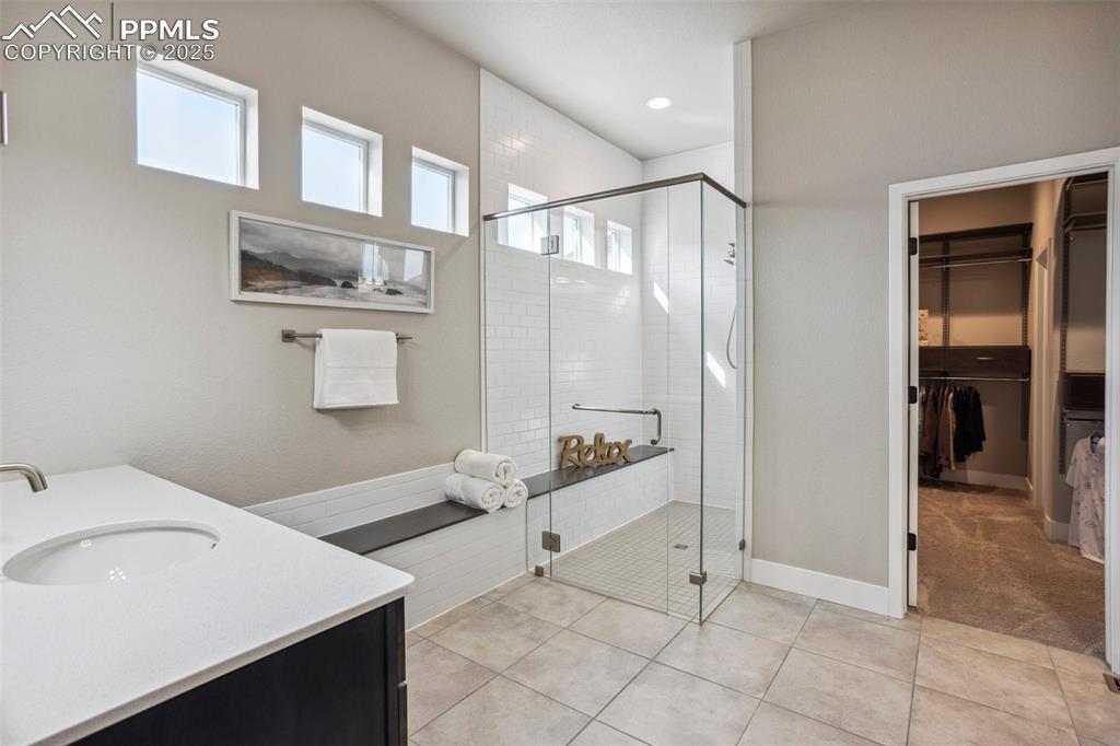 Image 18 of 48: Large, Frameless Shower with floor to ceiling tile & quartz bench runs in/o