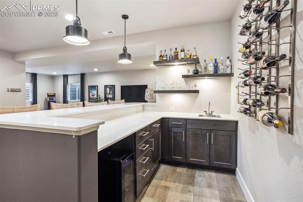 Image 22 of 48: Wet Bar with pendant lights, wine rack, lighted shelving & wine cooler, sof