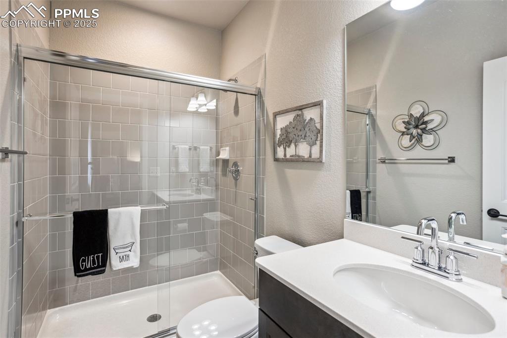 Image 27 of 48: en-suite third bathroom with tile floor & quartz counters