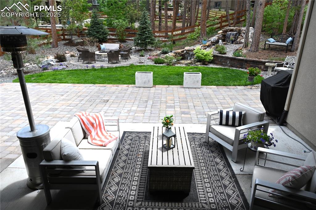 Image 39 of 48: Lush landscaping, spacious covered patio plus custom extension for corn hol