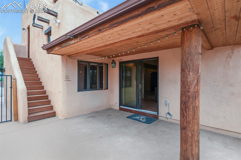 Image 28 of 48: Back patio and upstairs to bedroom and bathroom with private entrance.