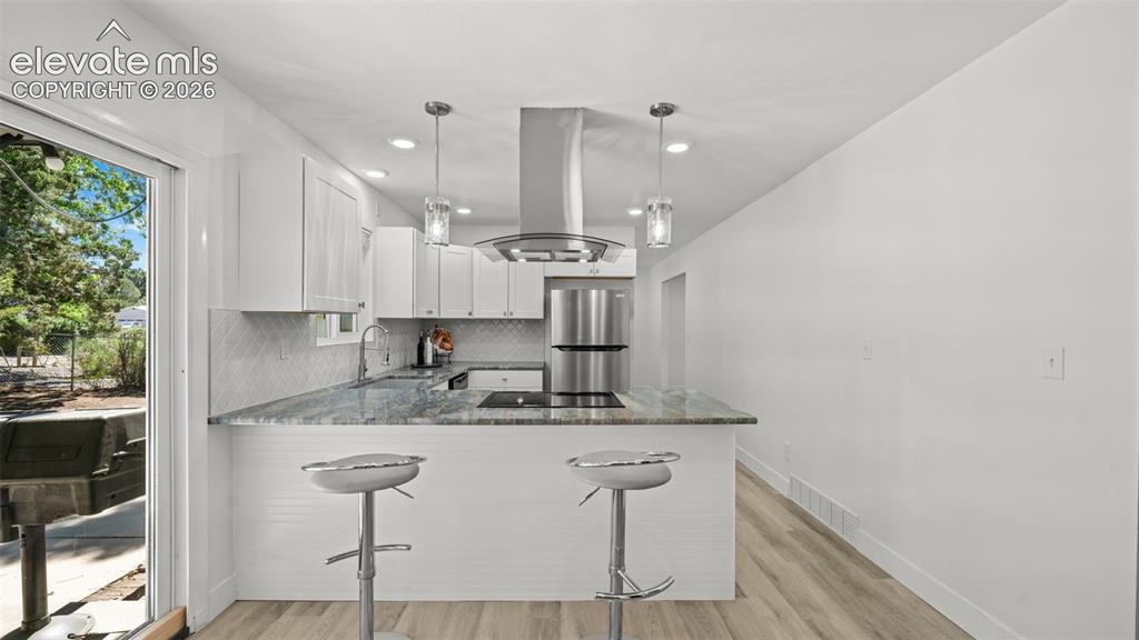 Image 13 of 44: Kitchen featuring white cabinetry, stainless steel appliances, recessed lig