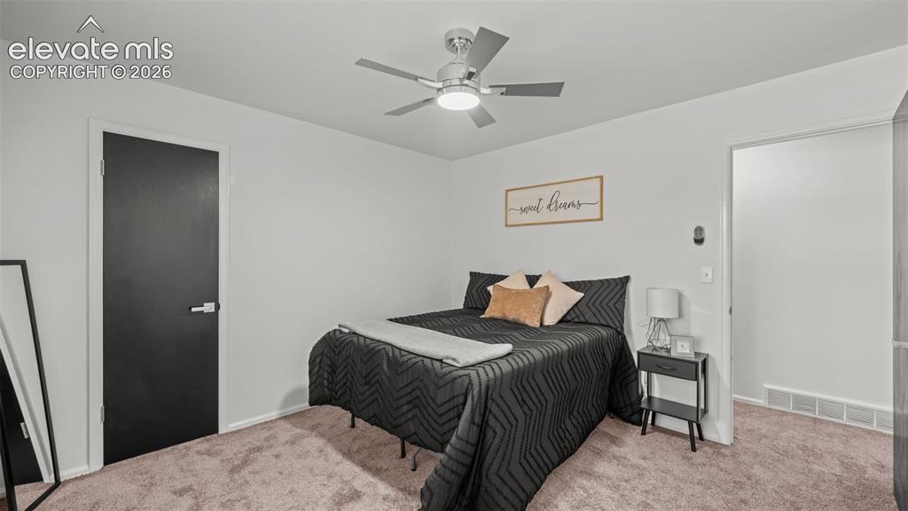 Image 21 of 44: Light-toned walls, ceiling fan with integrated lighting, dark interior door