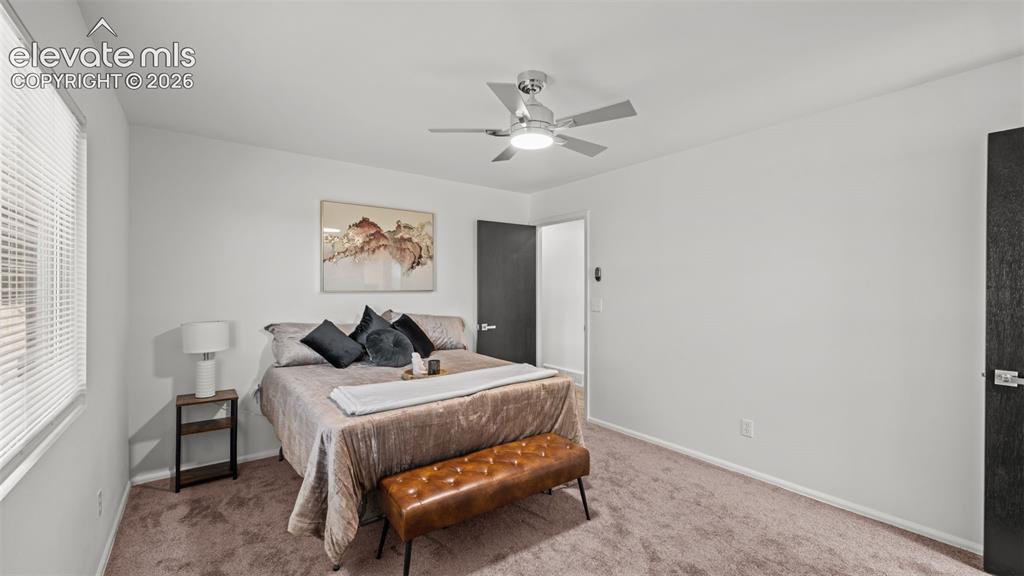 Image 25 of 44: Light-filled room featuring neutral wall paint, ceiling fan, and carpeted f