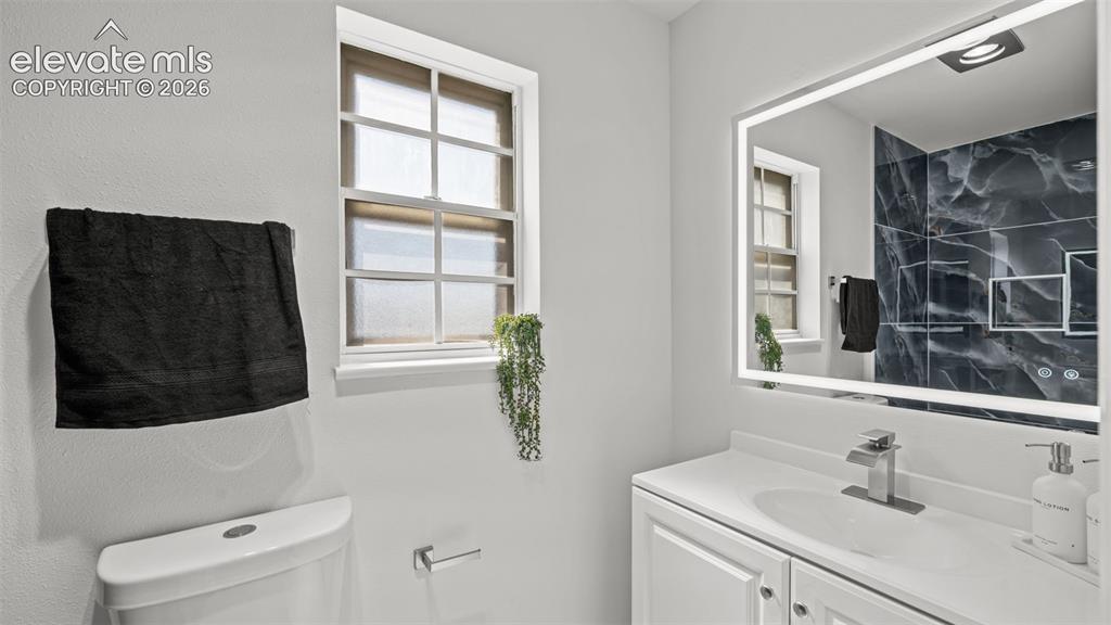 Image 26 of 44: White single vanity with integrated sink and chrome faucet