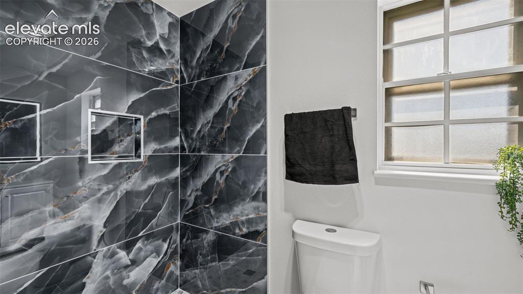 Image 27 of 44: Large format dark grey veined tile, integrated shower niches, white framed 