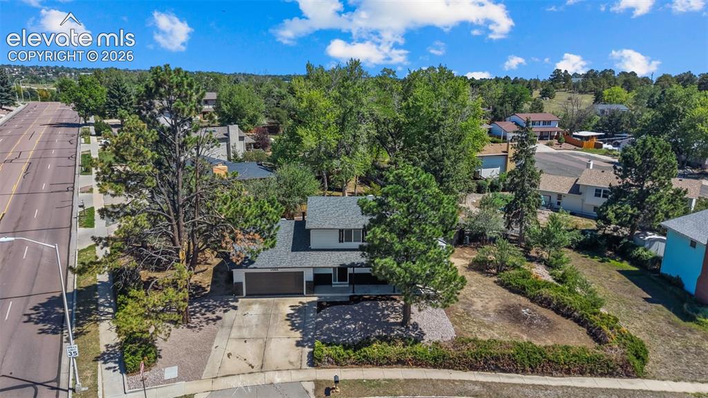 Image 33 of 44: Aerial view of a contemporary home situated on a landscaped lot featuring m