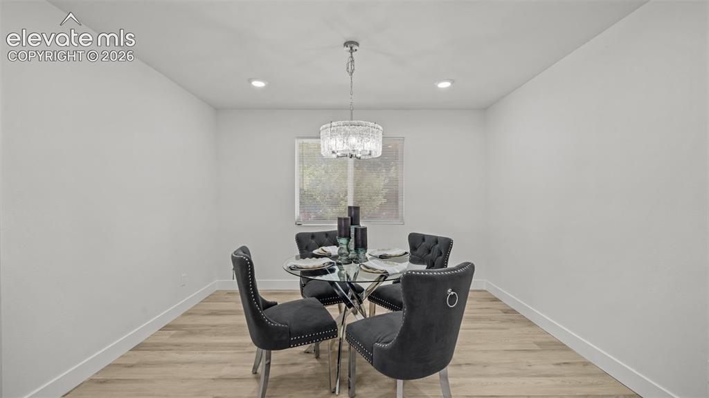 Image 9 of 44: Recessed lighting, wood-finish flooring, and a window providing natural lig