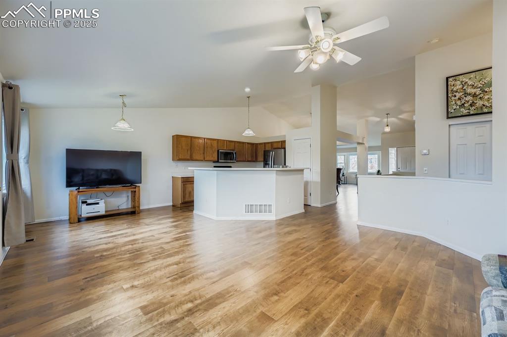 Image 13 of 29: Unfurnished living room with light wood-type flooring, lofted ceiling, and 
