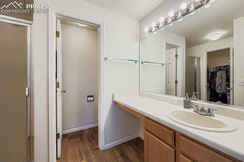 Image 16 of 29: Full bath featuring a stall shower, vanity, dark wood-style floors, and a s