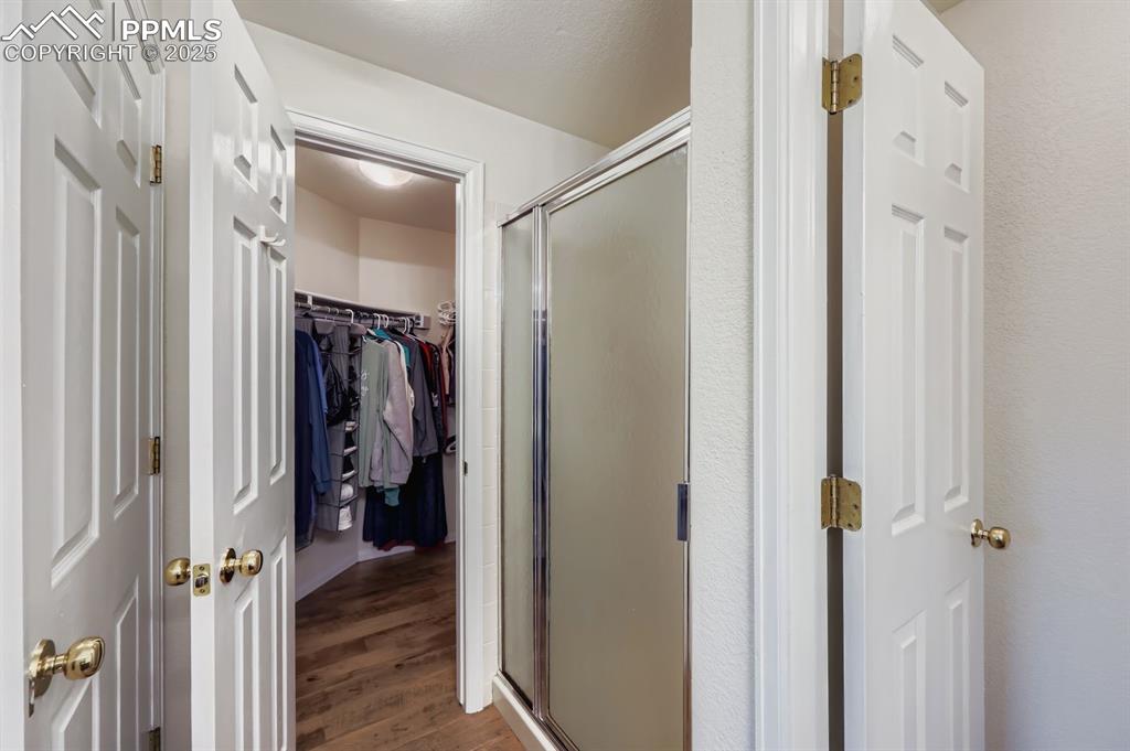 Image 17 of 29: Full bathroom featuring dark wood finished floors, a spacious closet, and a