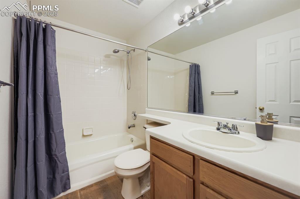 Image 20 of 29: Full bathroom featuring shower / bath combo, vanity, and dark wood-style fl