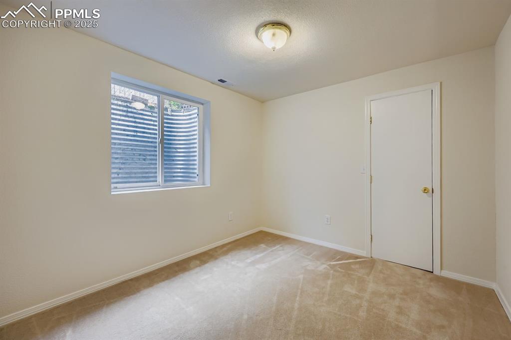 Image 23 of 29: Empty room with light carpet and a textured ceiling