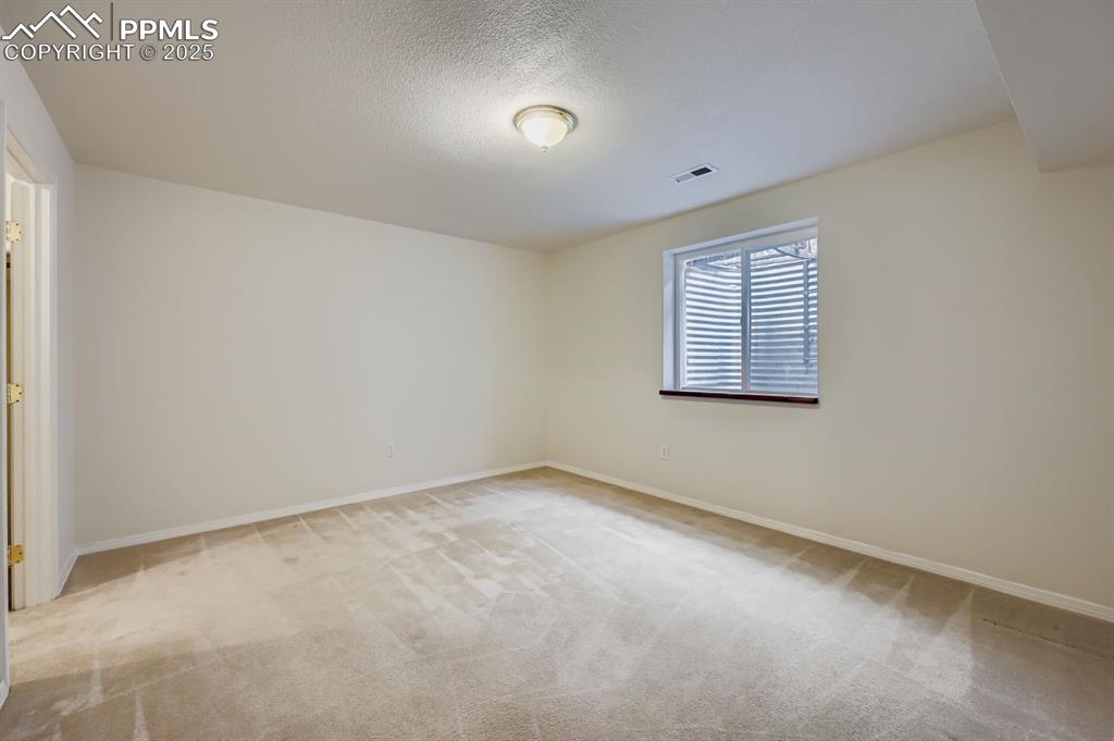 Image 24 of 29: Unfurnished room with light carpet and a textured ceiling