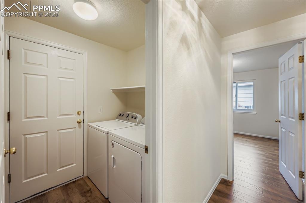 Image 27 of 29: Washroom featuring dark wood-style floors, separate washer and dryer, and a