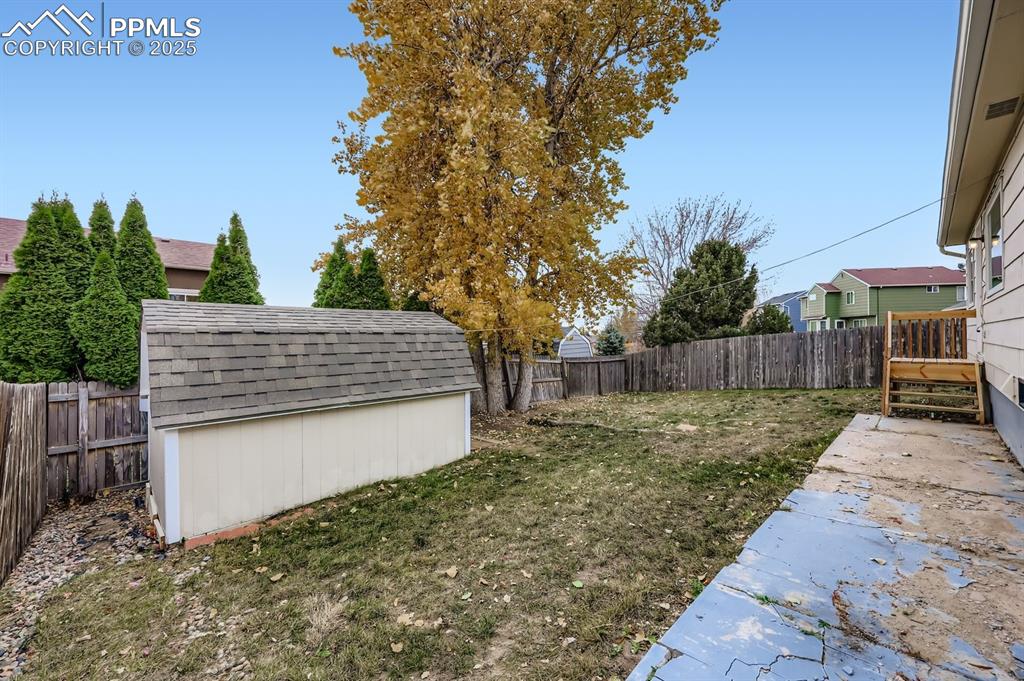 Image 28 of 29: Fenced backyard featuring a shed