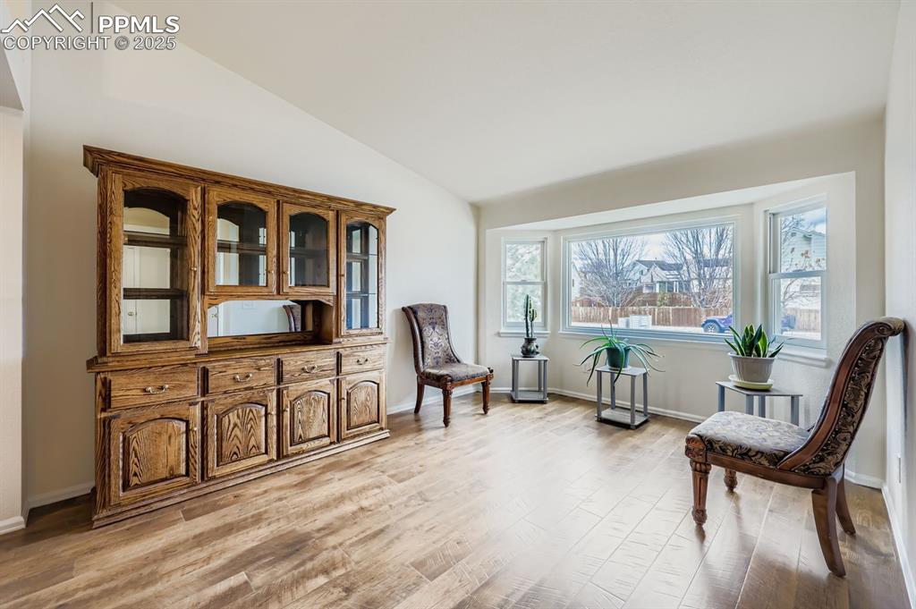 Image 5 of 29: Living area with lofted ceiling and light wood-style flooring