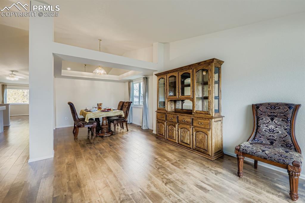 Image 6 of 29: Dining room featuring light wood-type flooring, a raised ceiling, and a cei