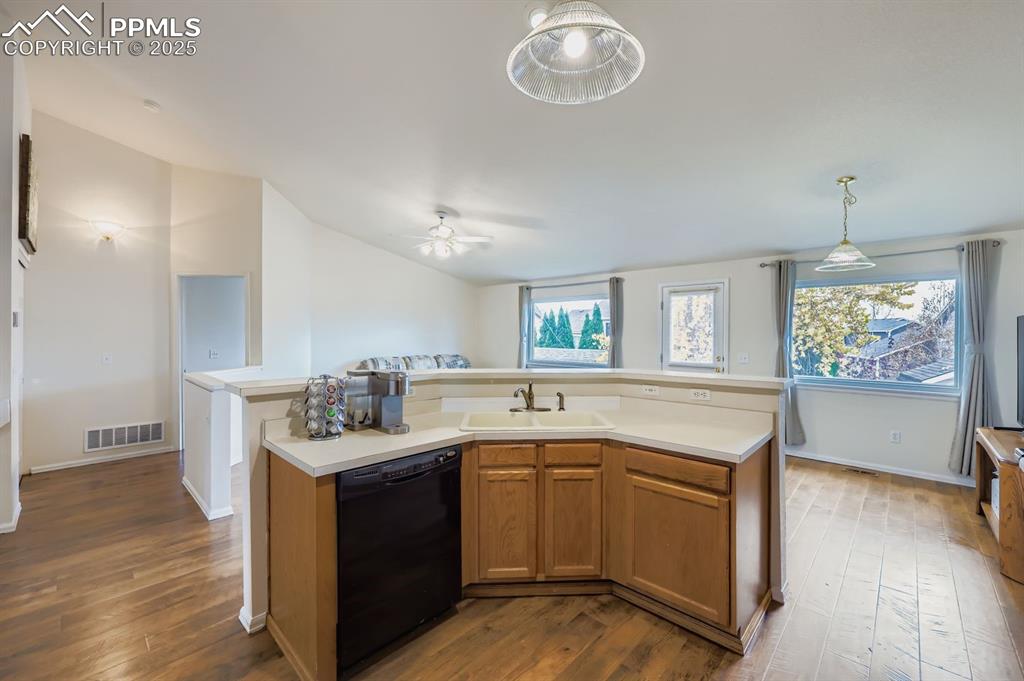 Image 9 of 29: Kitchen with a kitchen island with sink, oak cabinets, light countertops, d