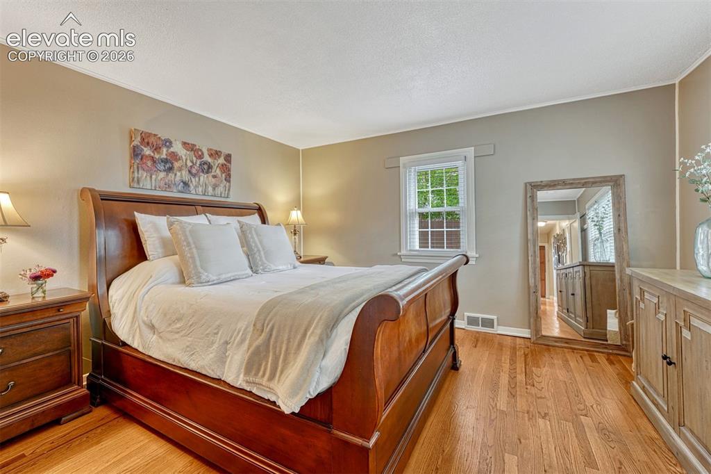 Image 22 of 50: Light-filled primary bedroom with a wall of windows.