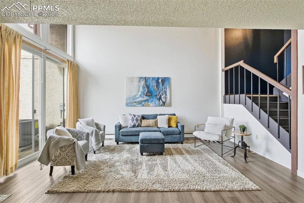 Image 12 of 45: Living room with wood finished floors and stairs