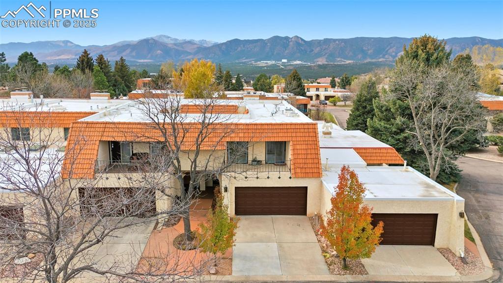Image 37 of 45: View of front of home featuring a mountain view, stucco siding, and concret