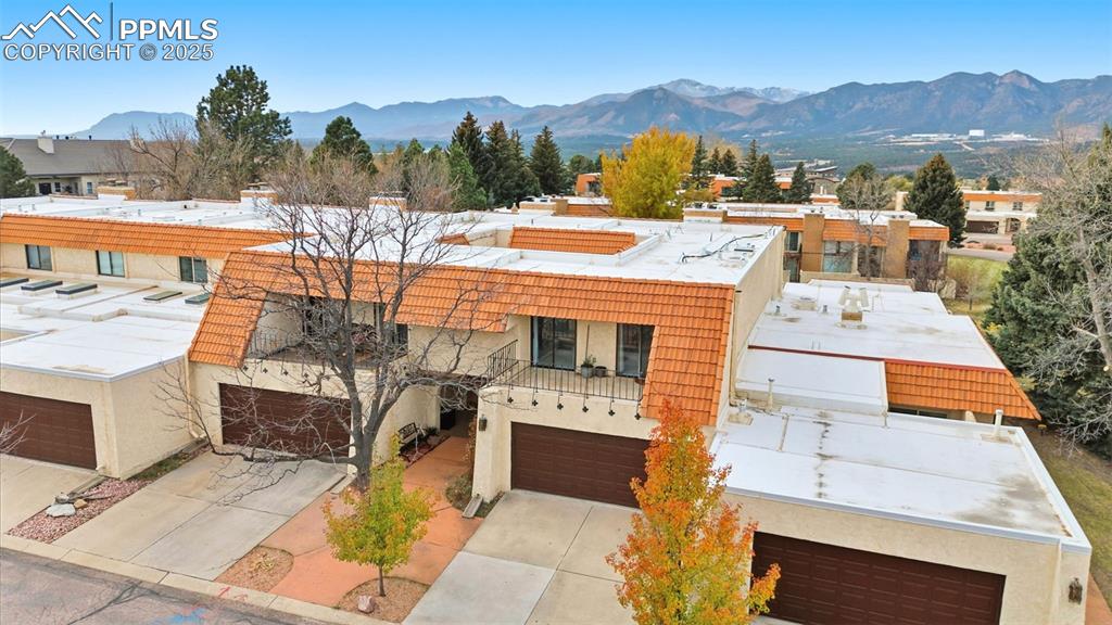 Image 39 of 45: View of front of home featuring a mountain view, stucco siding, and drivewa