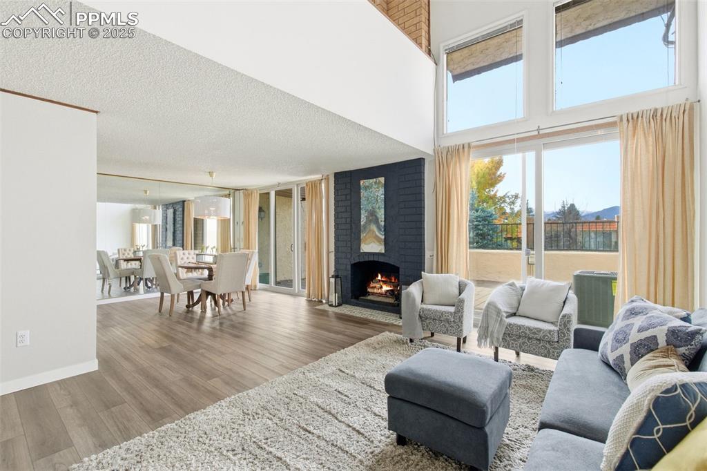 Image 9 of 45: Living area featuring plenty of natural light, wood finished floors, a fire
