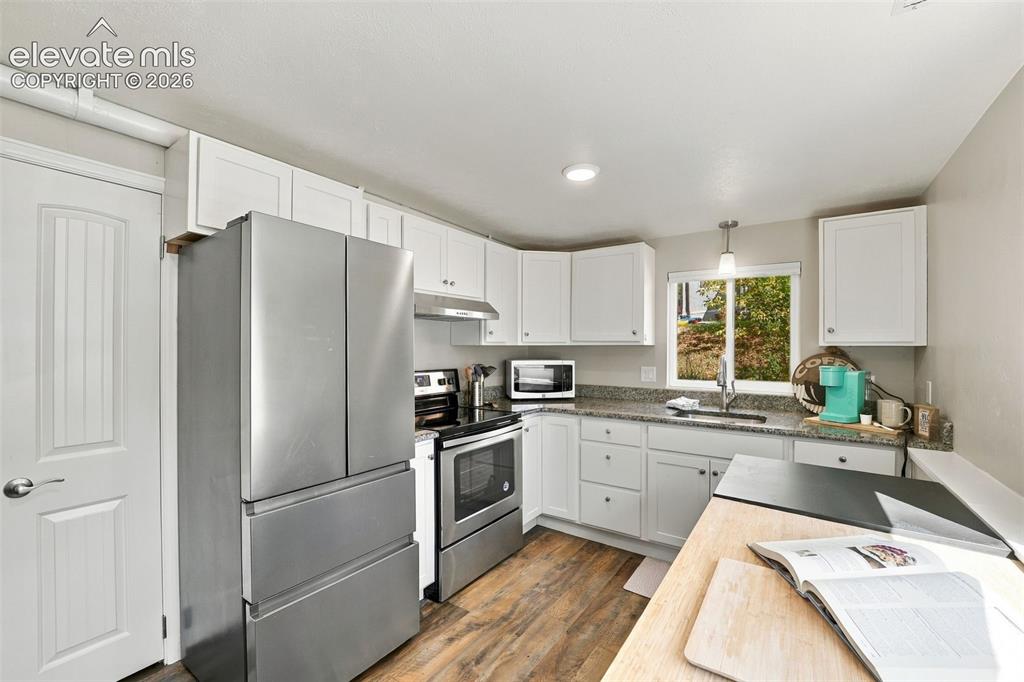 Image 37 of 50: Lower level kitchen has luxury vinyl flooring and stainless steel appliance