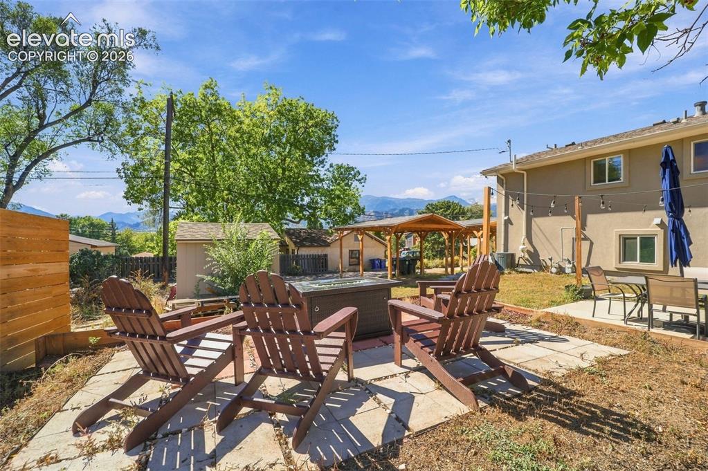 Image 41 of 50: A gas fire pit in the back corner of the Back yard