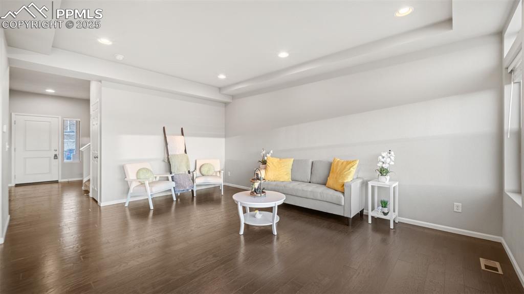 Image 10 of 48: Sitting room with recessed lighting and dark wood-style flooring