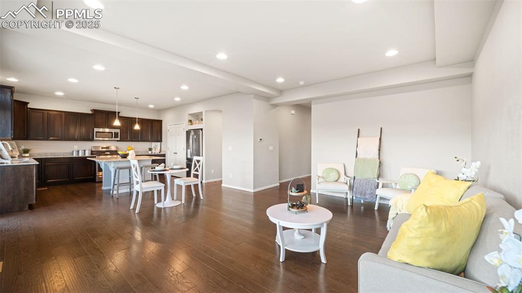 Image 11 of 48: Living room featuring dark wood-style flooring, recessed lighting, and beam