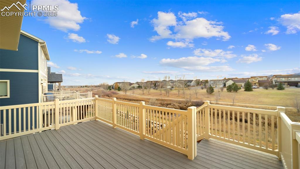 Image 21 of 48: Wooden deck featuring a view of the walking trail and open space