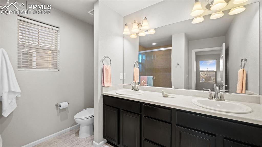 Image 29 of 48: Primary Bathroom featuring double vanity and a shower stall
