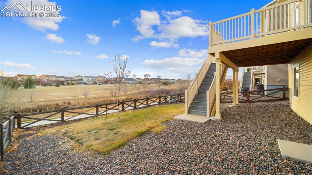 Image 35 of 48: View of yard featuring a deck, stairway, and a residential view