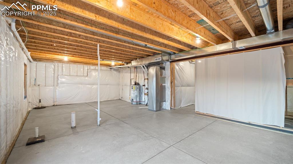 Image 36 of 48: Unfinished below grade area with heating unit and gas water heater