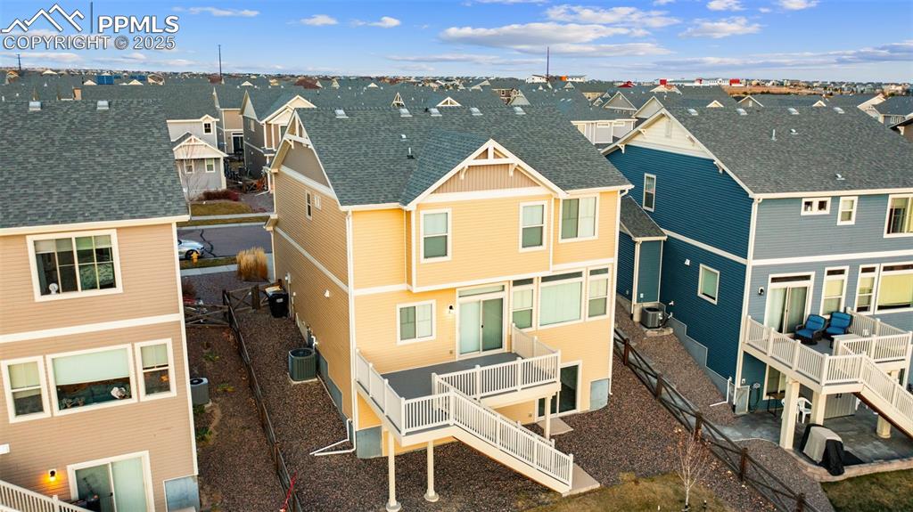 Image 38 of 48: Back of house featuring a residential view, a wooden deck, a shingled roof,