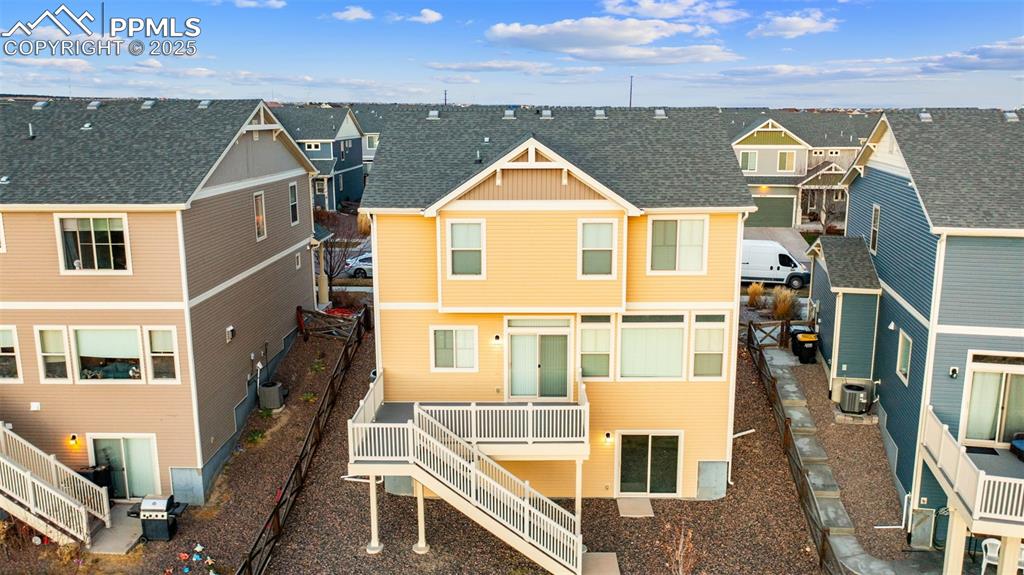 Image 39 of 48: Back of house with a residential view, roof with shingles, a deck, and stai