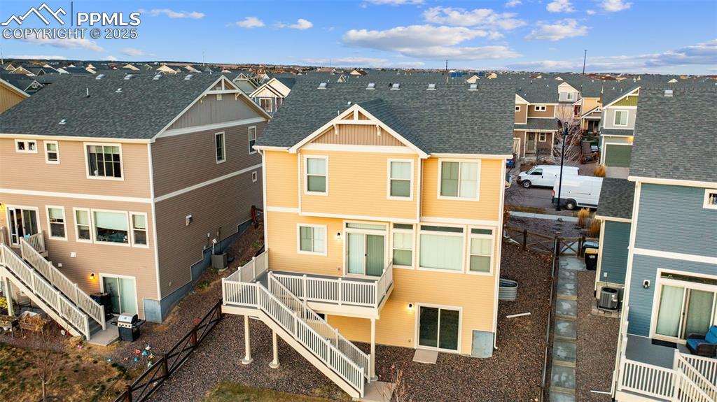 Image 40 of 48: Rear view of house featuring a residential view, roof with shingles, stairw