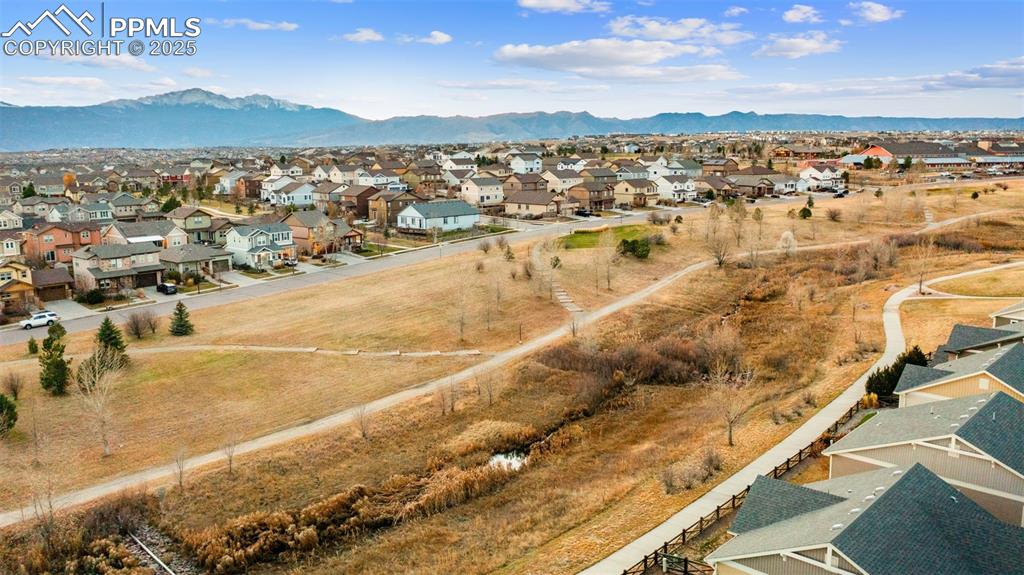 Image 42 of 48: Aerial view of residential area with a mountain backdrop
