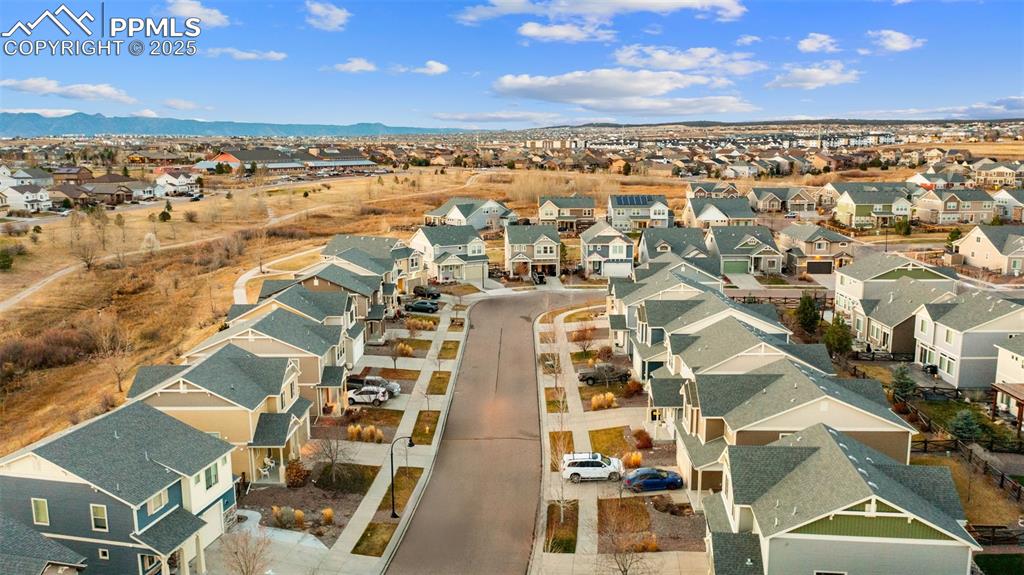 Image 44 of 48: Aerial view of residential area with a mountain backdrop