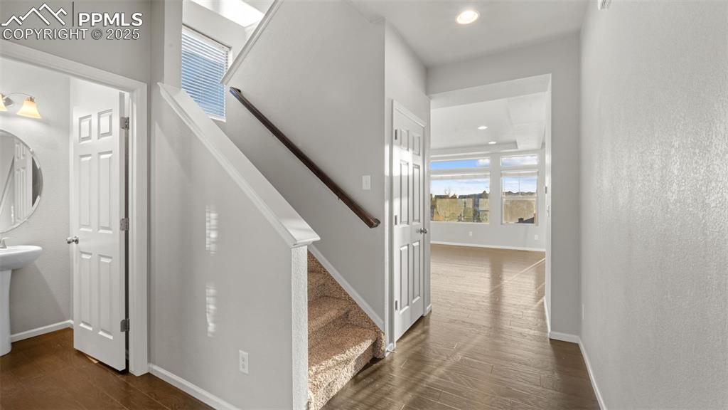 Image 8 of 48: Stairs with plenty of natural light, wood finished floors, a textured wall,