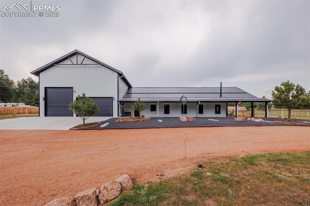 Caption: View of front of house with circular drive and landscaping  