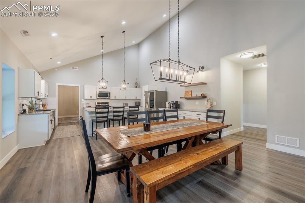 Image 15 of 38: Dining area with high vaulted ceiling