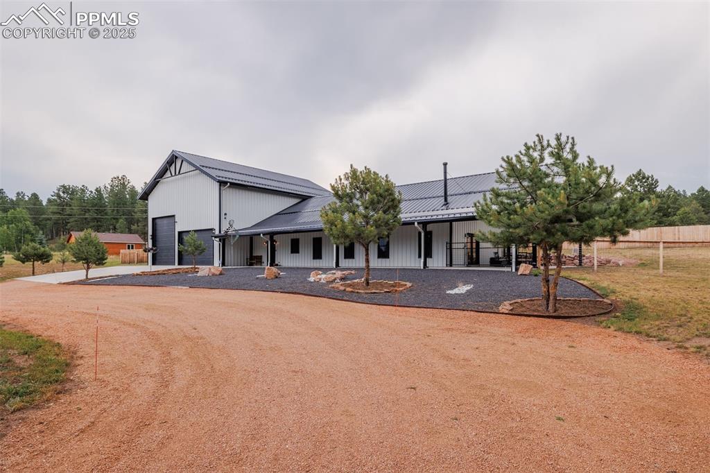 Image 2 of 38: View of front of house featuring gravel driveway and a garage