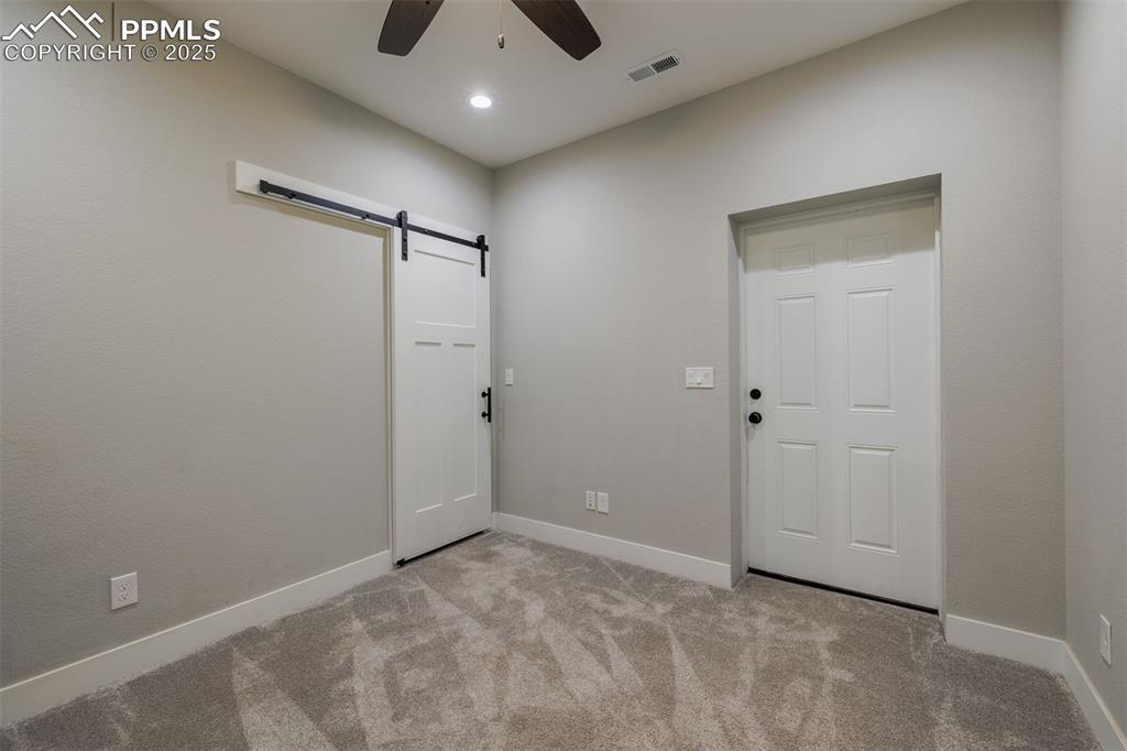 Image 31 of 38: Office with barn door, ceiling fan, and recessed lighting